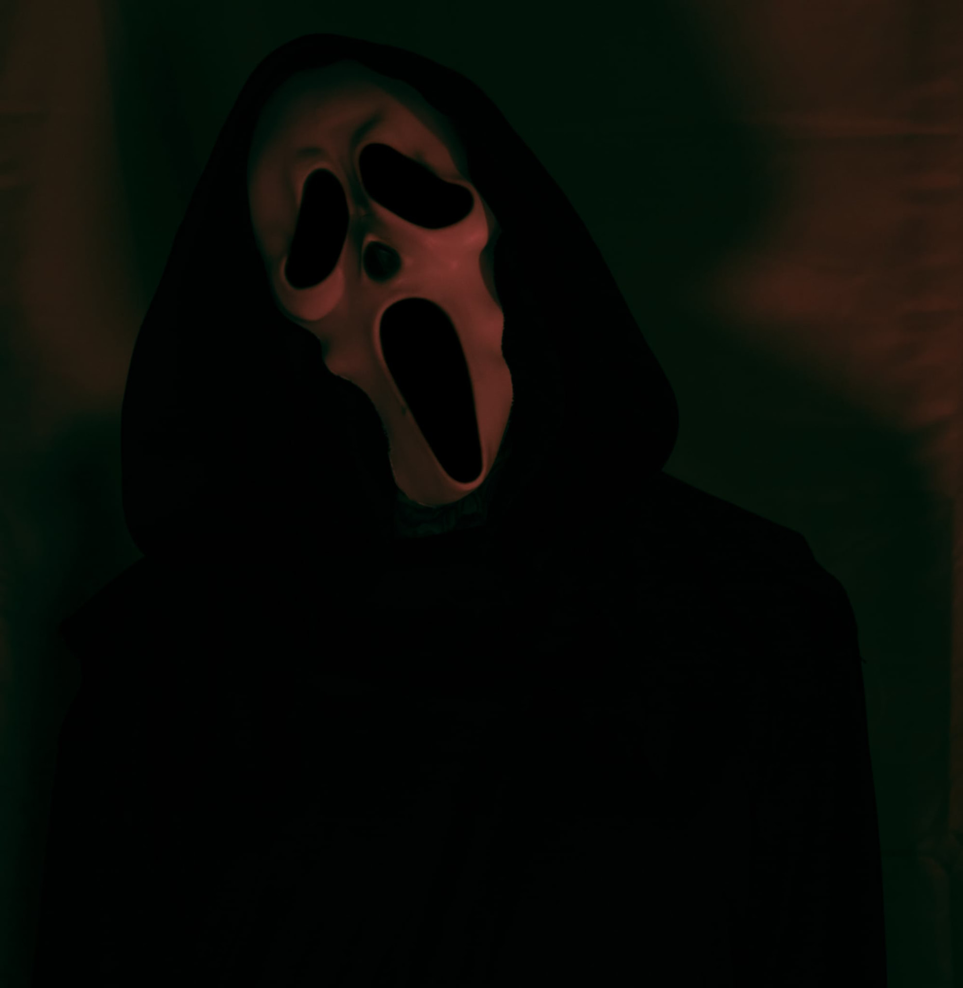 Themed Halloween portrait with a ghost mask in dramatic light